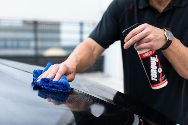 Car being polished with a buffing tool, close-up on the front fender and headlight
