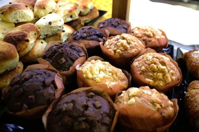 Assortimento di muffin e scones in pirottini di carta, alcuni con gocce di cioccolato.