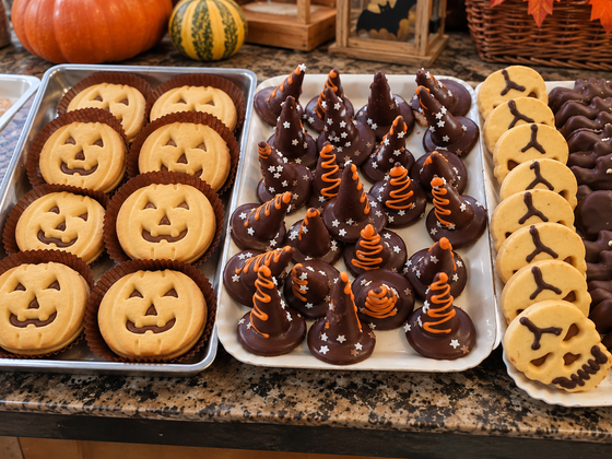 Vassoio di biscotti alla zucca e dolcetti di Halloween al cioccolato sul piano di lavoro