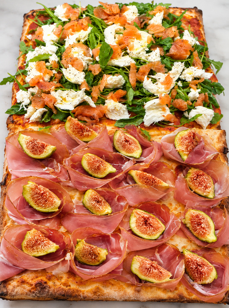 Pizza in due sezioni: fettine di fico e prosciutto sotto, verdure a foglia con formaggio e condimento all’arancia sopra