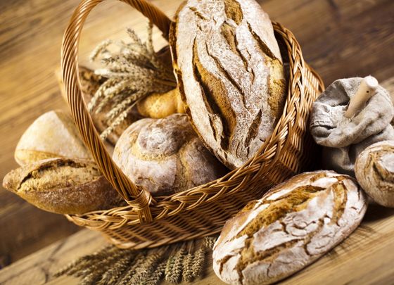 Cesto di vari tipi di pane rustico su un tavolo di legno