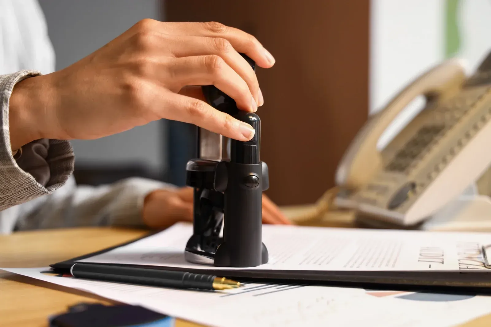 A person is putting a stamp on a piece of paper.