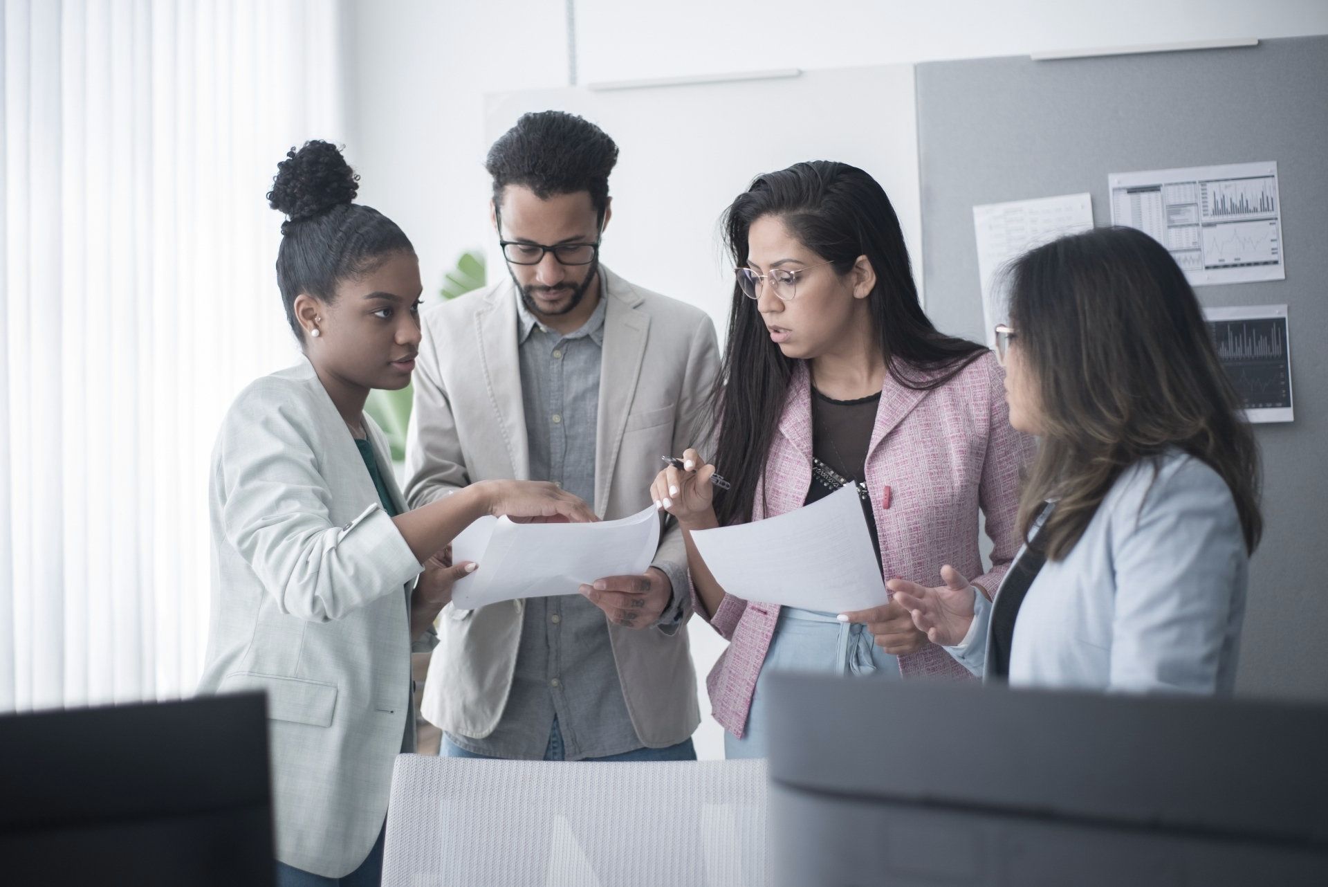 4 people looking at a sheet