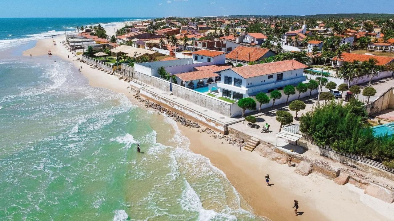 Uma vista aérea de uma praia com casas na costa. - Villa Manzuá