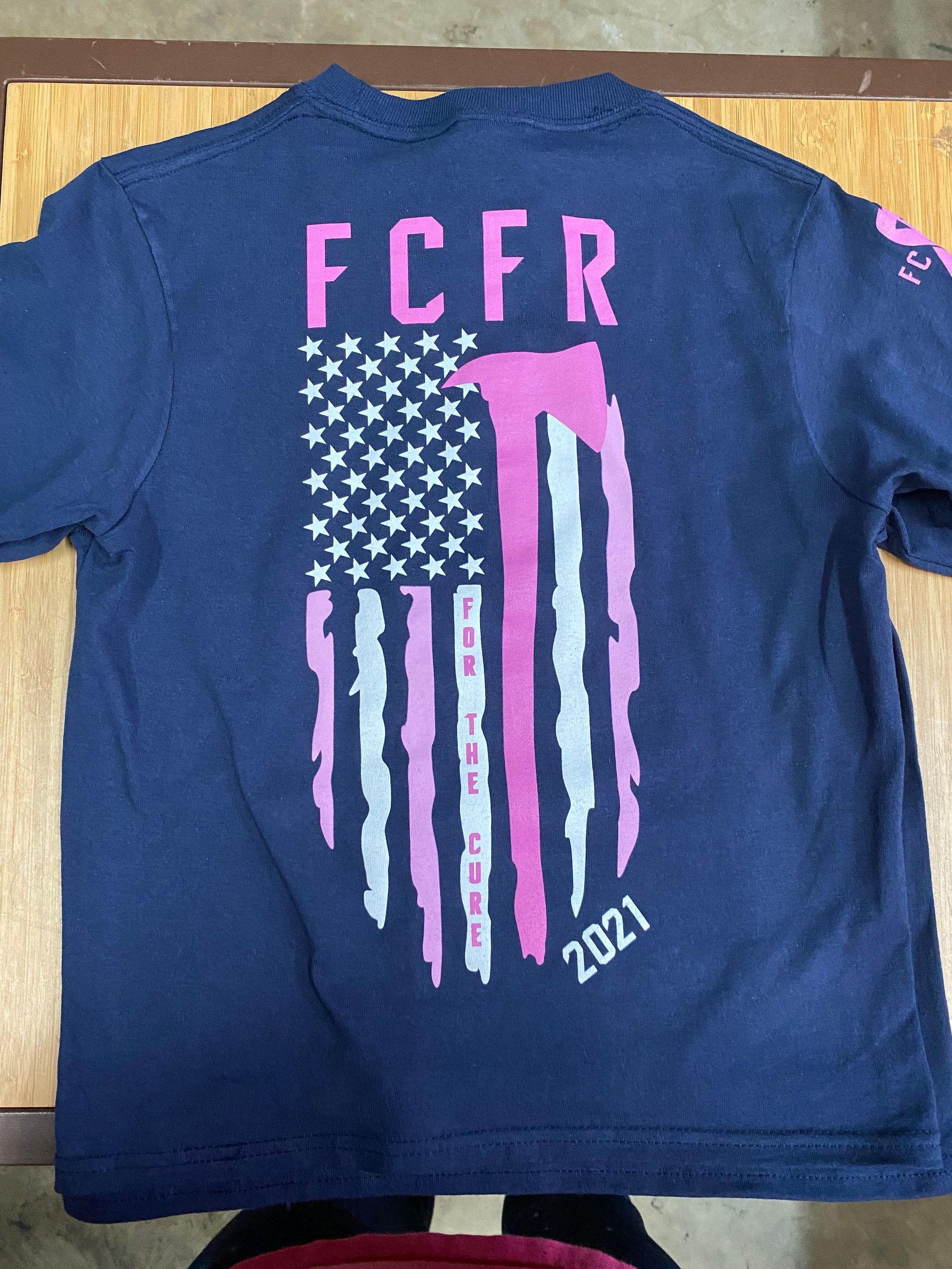 Navy T-shirt with pink FCER text and stylized American flag design, 2024
