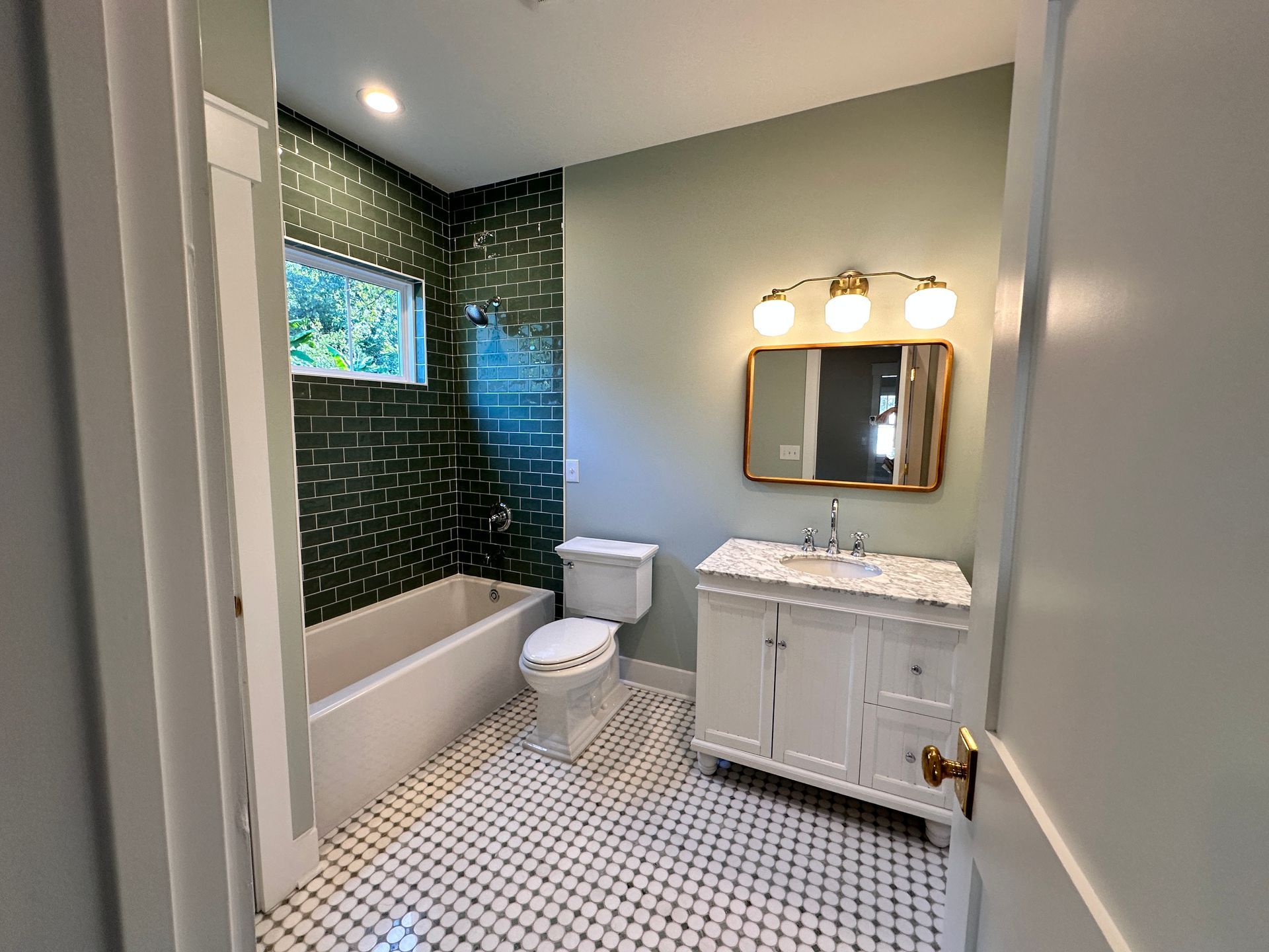A bathroom with a toilet , sink , bathtub and mirror.