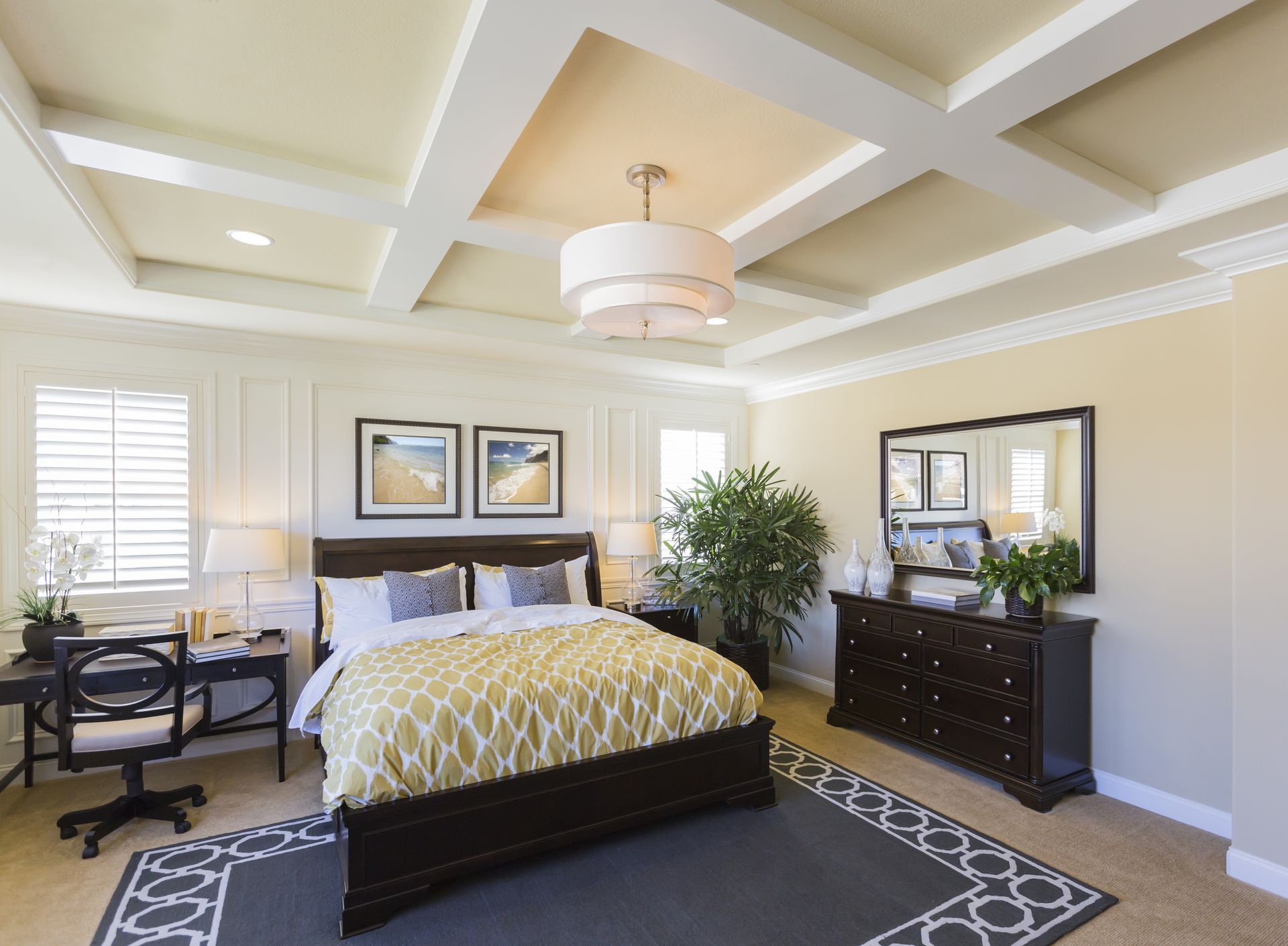 A bedroom with a king size bed , dresser , desk and chair.