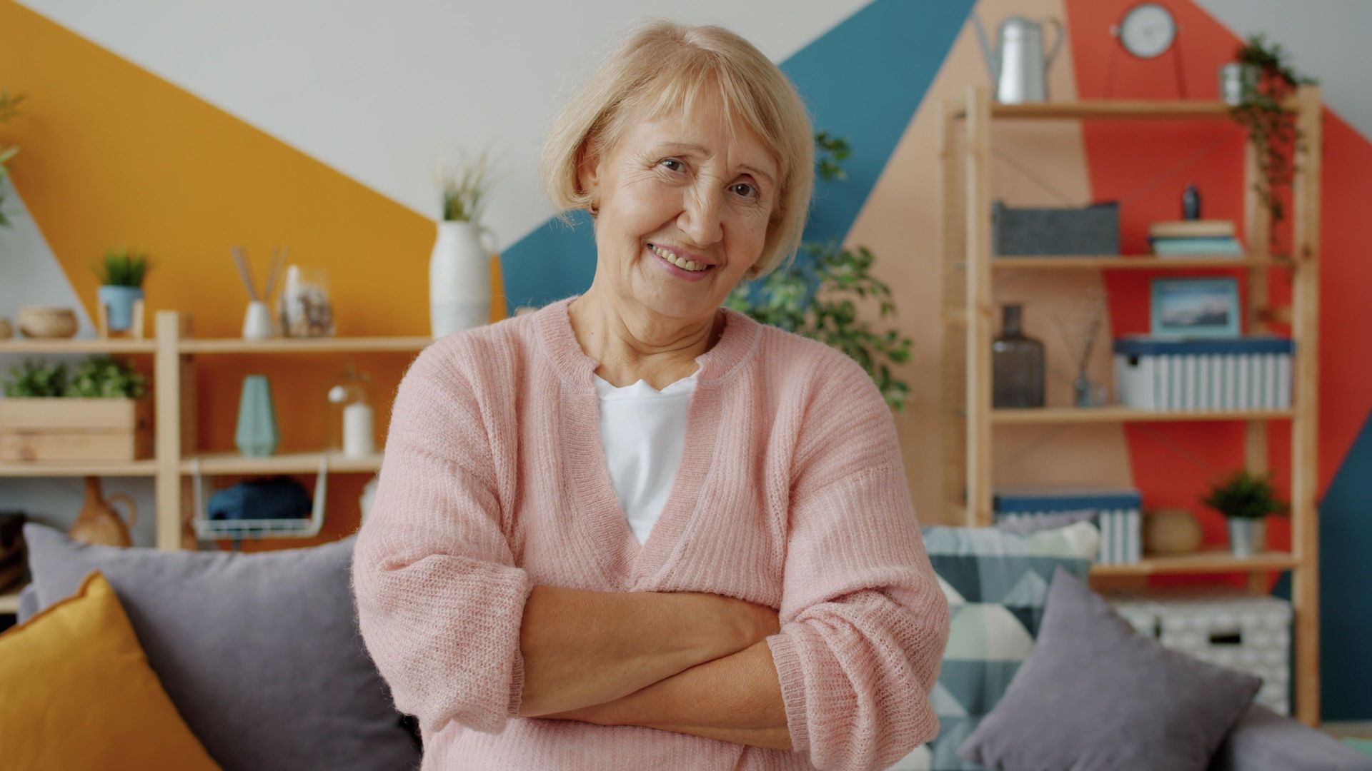 Een vriendelijke oudere vrouw glimlacht warm, een vertrouwd gezicht.