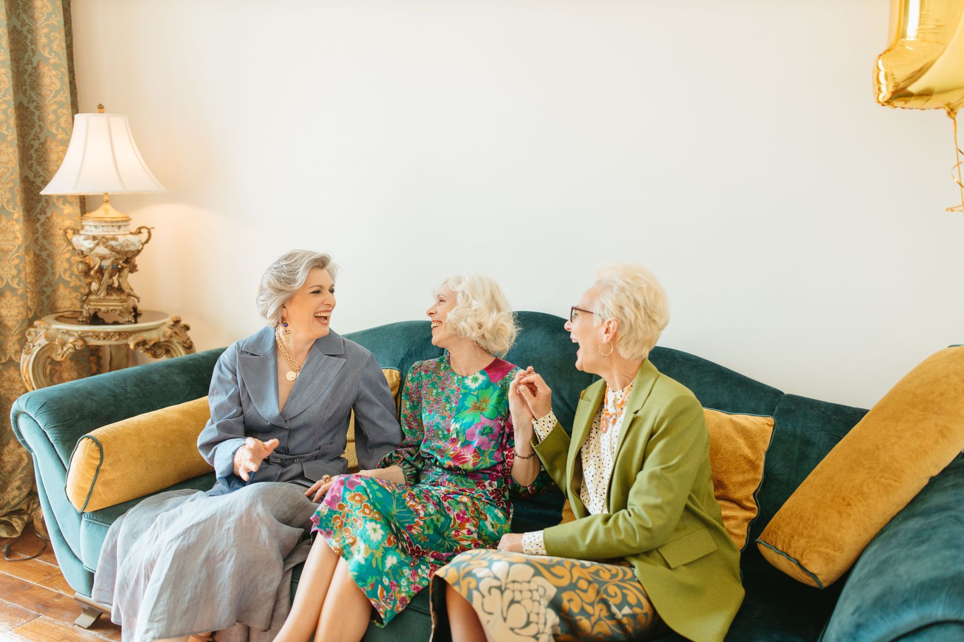 Drie oudere vriendinnen hebben een gezellig gesprek samen op de bank.