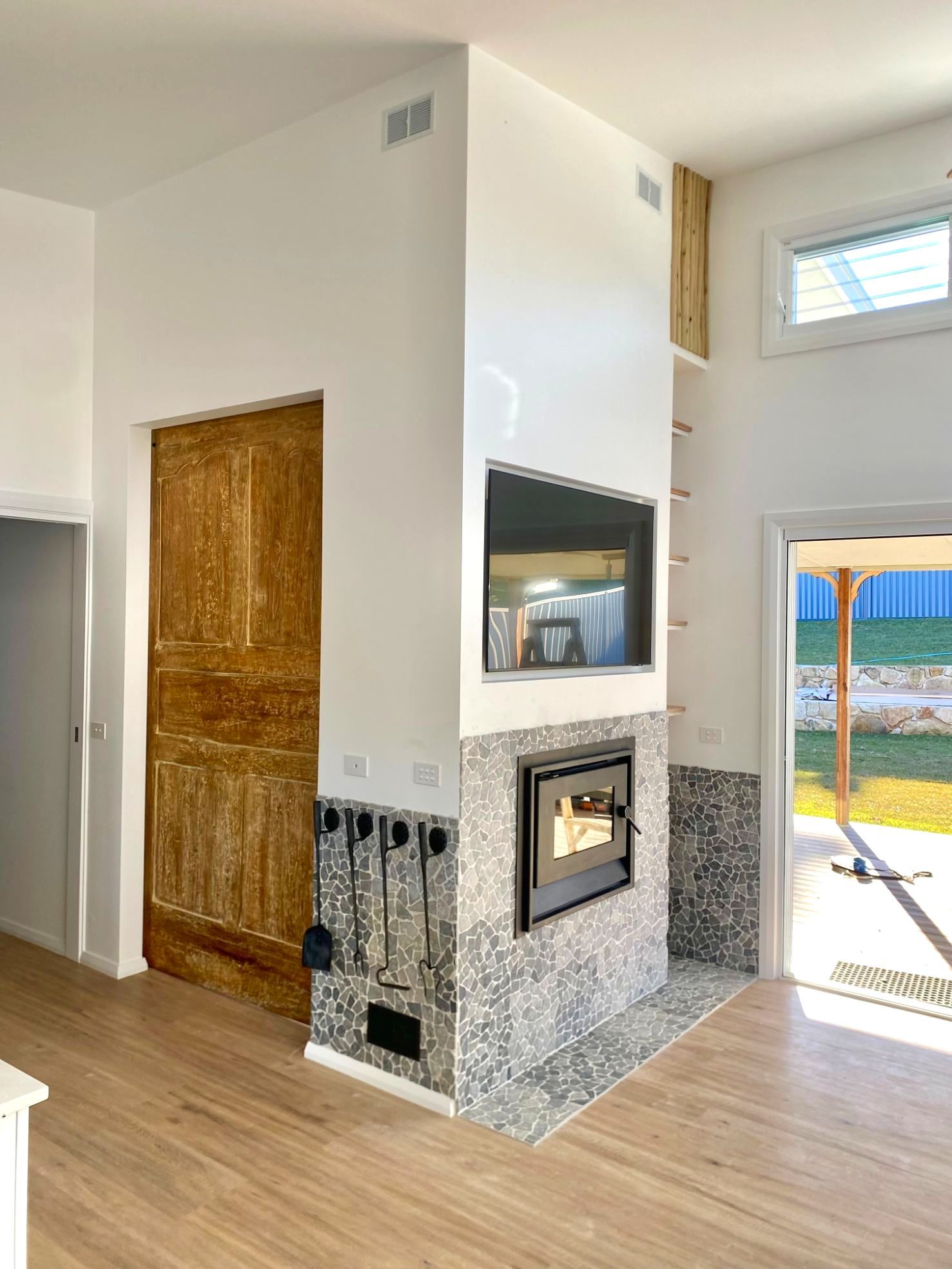 A Brick Building With A Large Window And A Wooden Deck — Nambucca Construction In Nambucca Heads, NSW