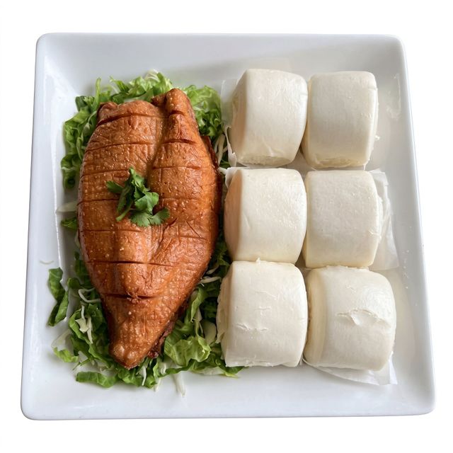 Grilled fish on greens beside six white rice cakes on a square white plate