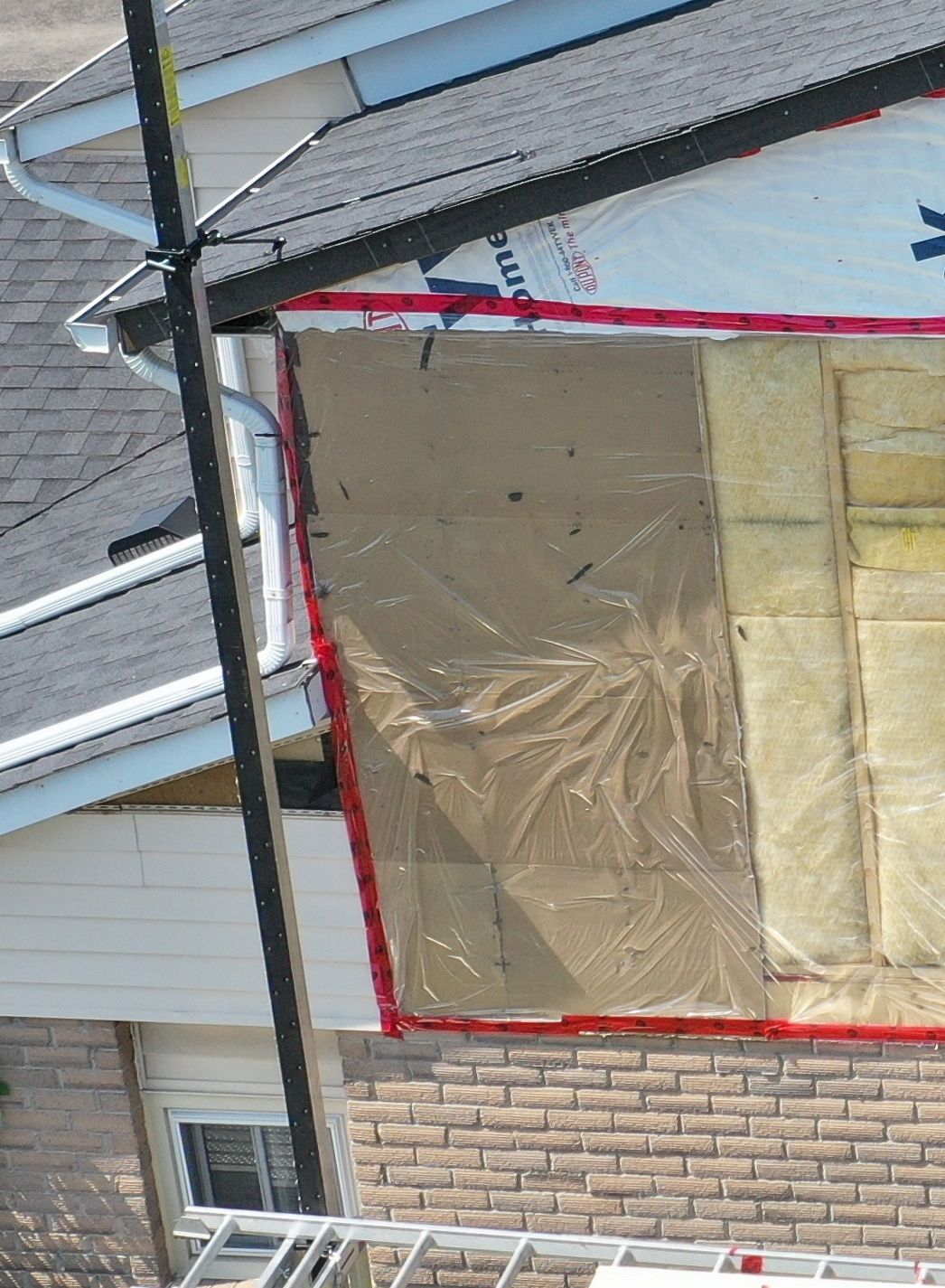 A house with a roof that is covered in plastic.