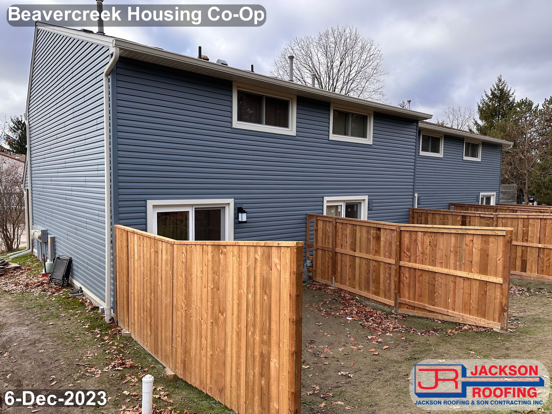 A blue house with a wooden fence in front of it