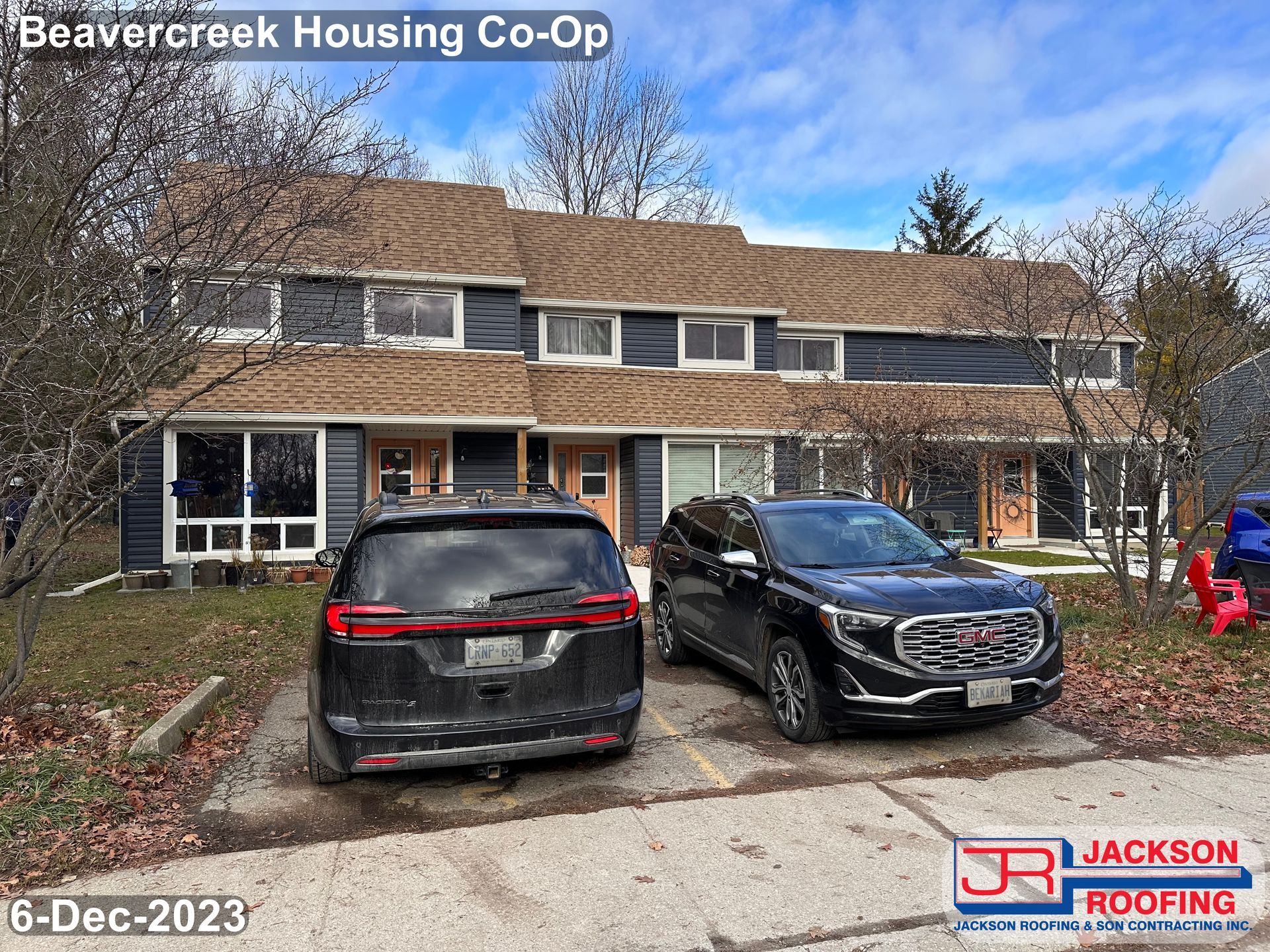 Two cars are parked in front of a house.