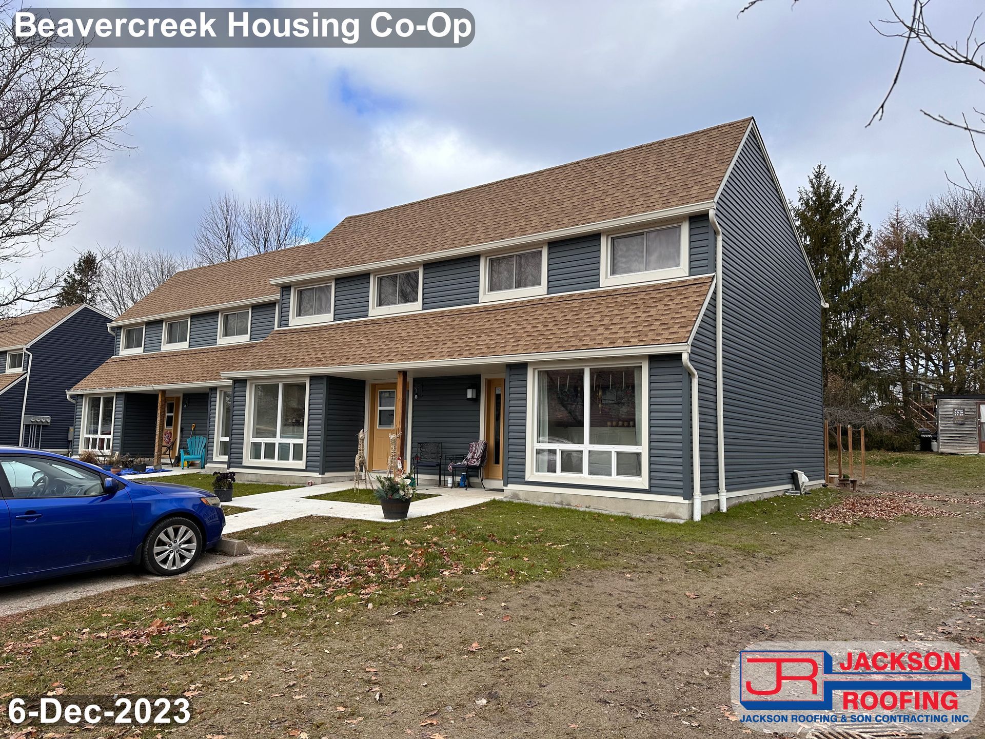 A blue car is parked in front of a beavercreek housing co-op.