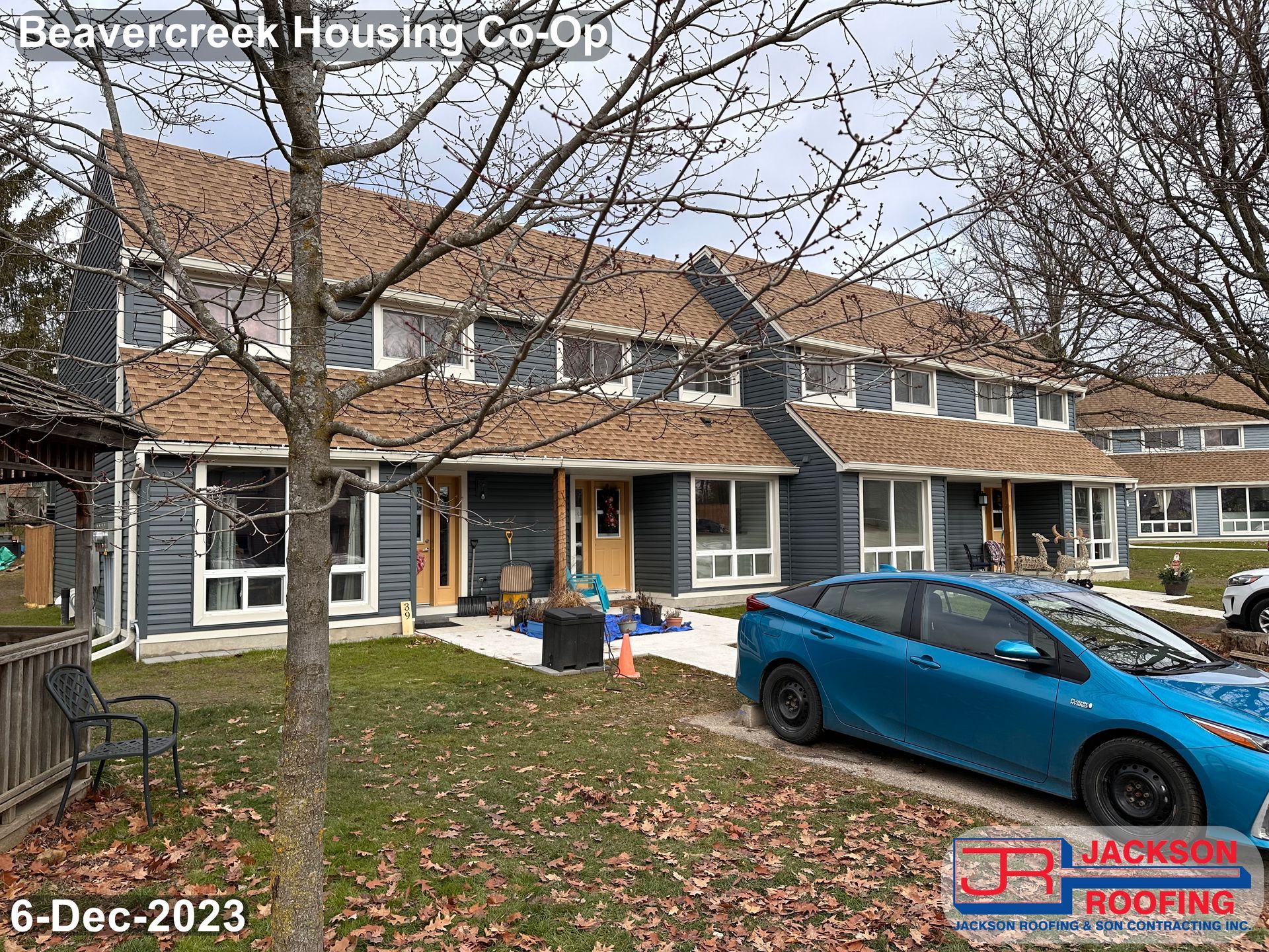 A blue car is parked in front of a house.