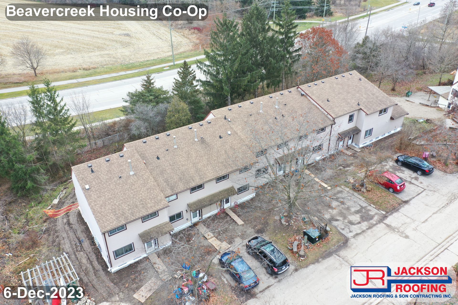 An aerial view of a building under construction with cars parked in front of it.