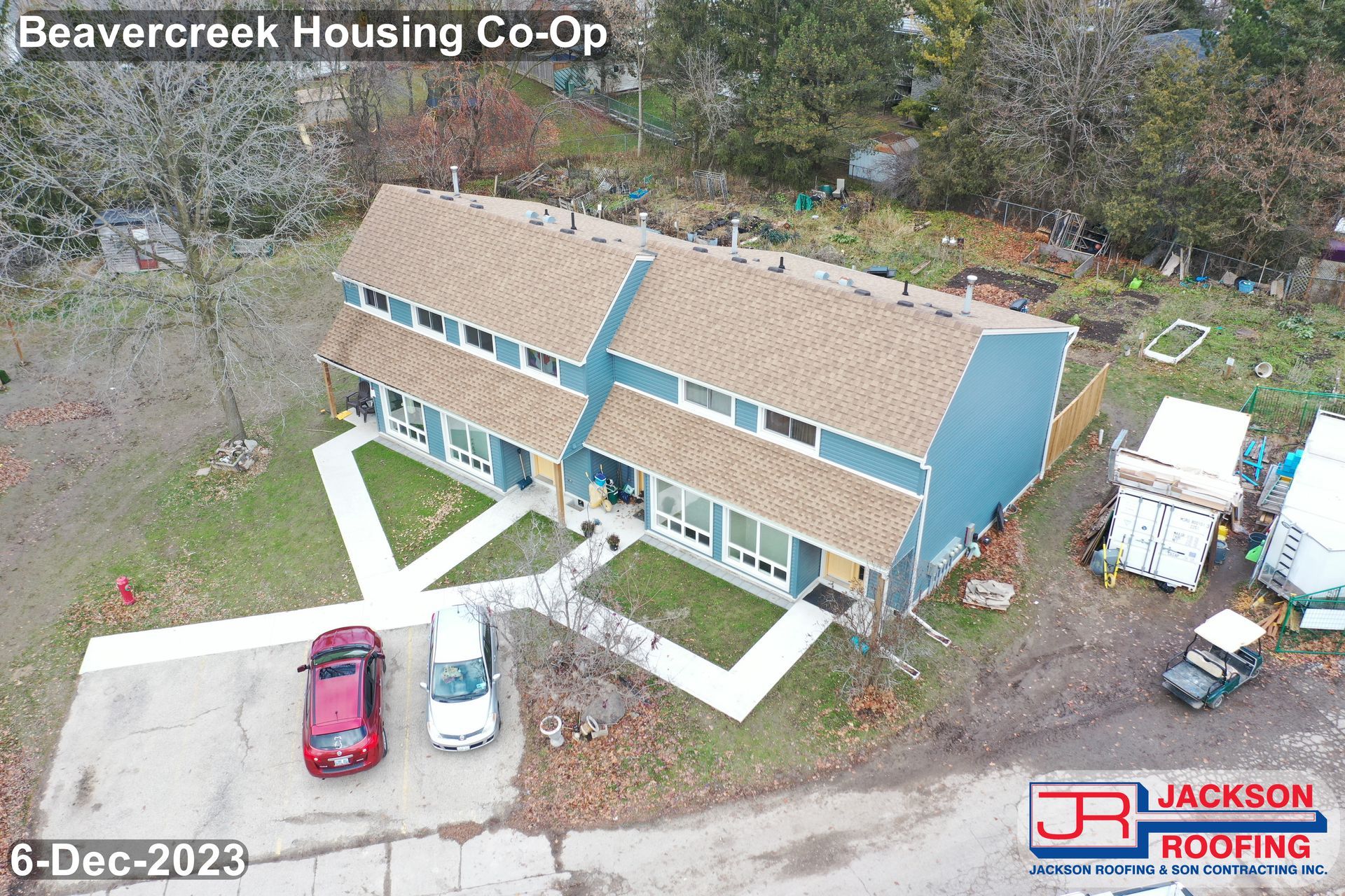 An aerial view of a house under construction with cars parked in front of it.