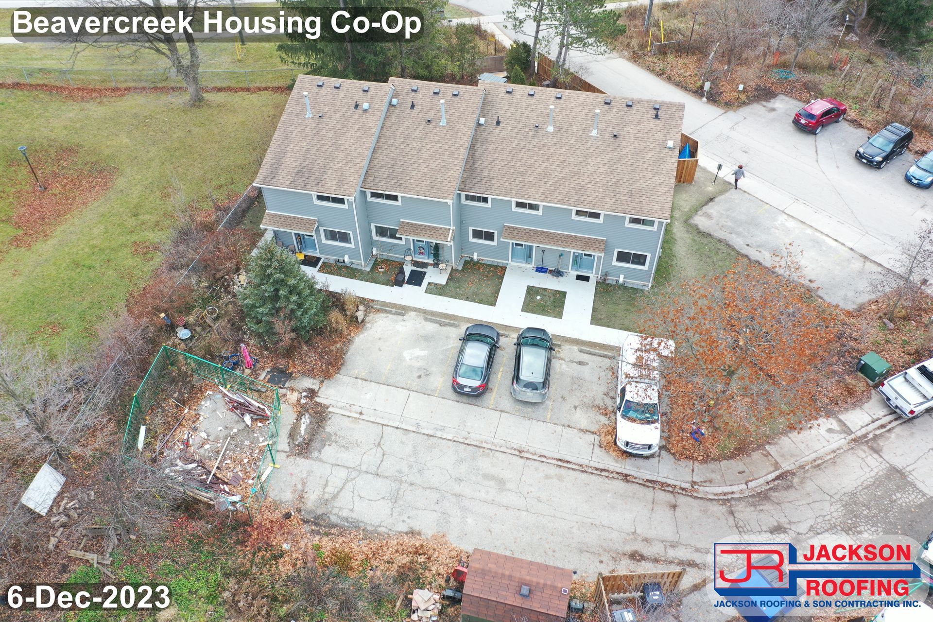 An aerial view of a row of houses with cars parked in front of them.