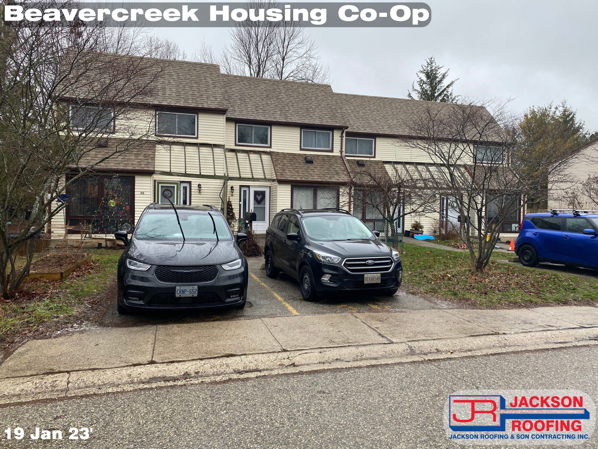 Two cars are parked in front of a house.