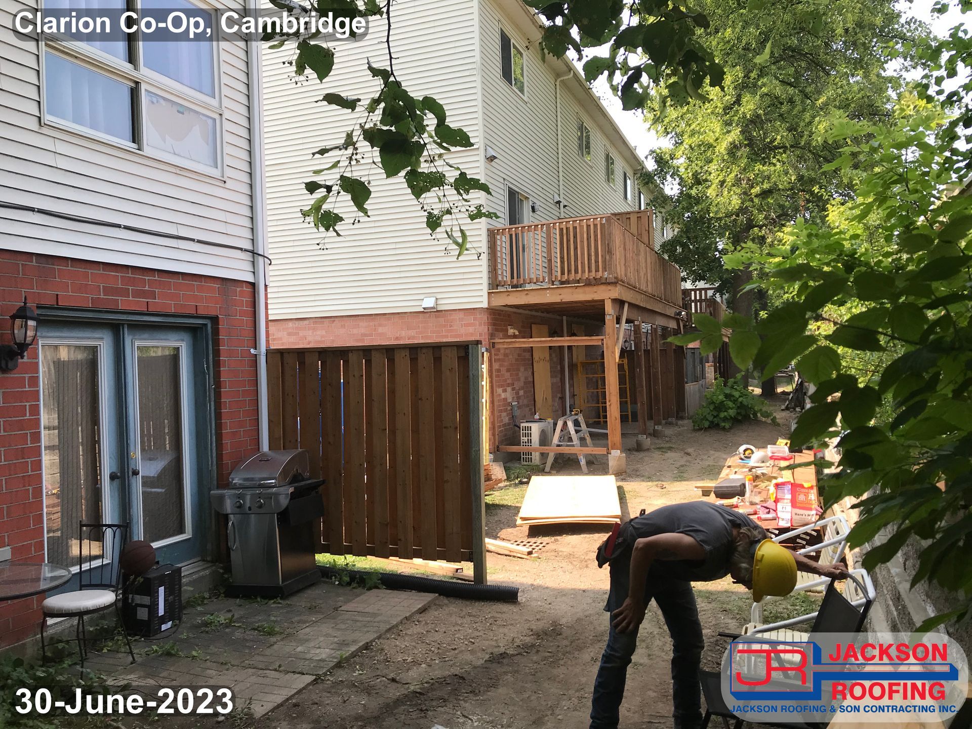 A man is working on a patio in front of a house.
