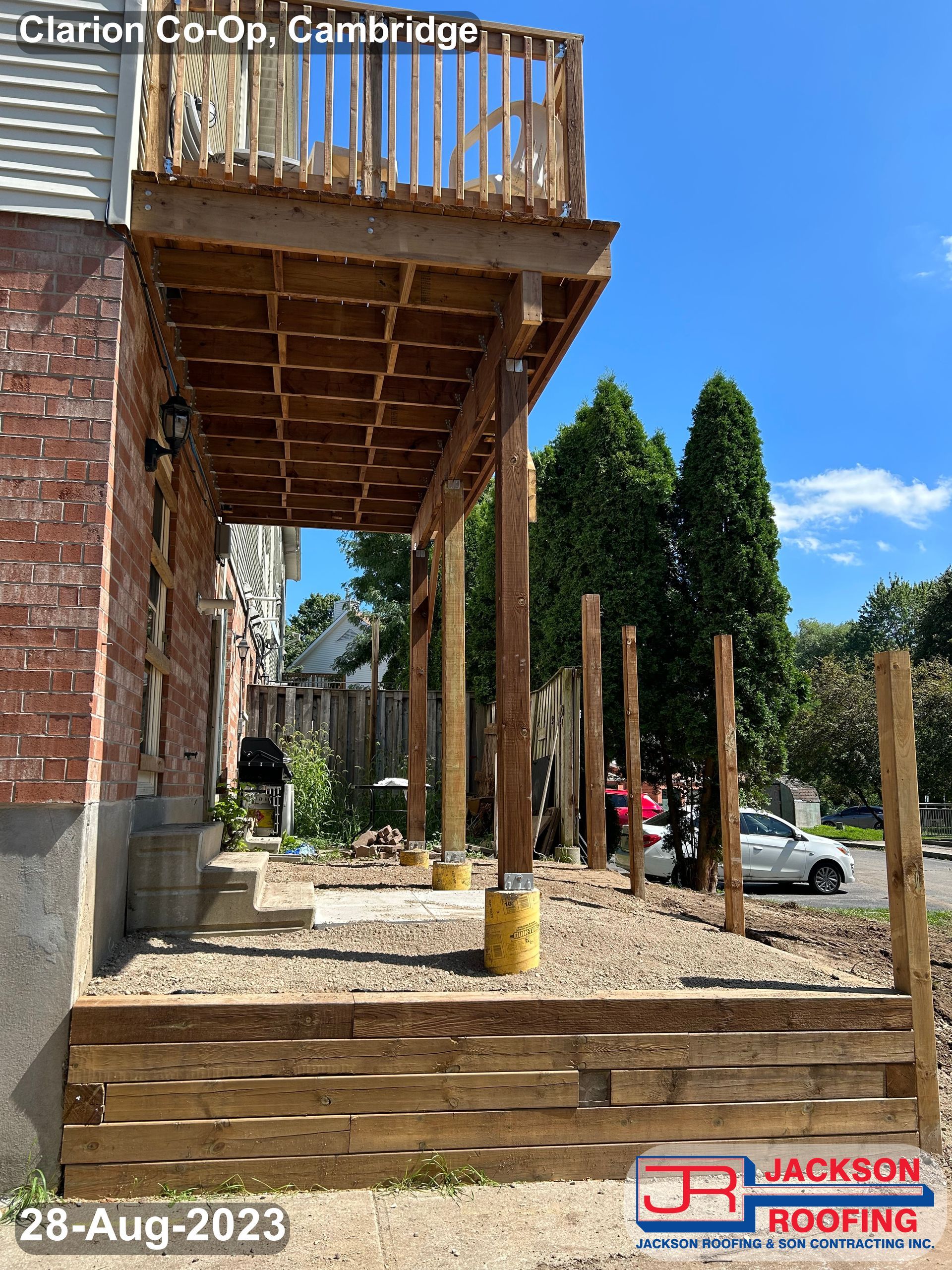 A wooden deck is being built on the side of a house.