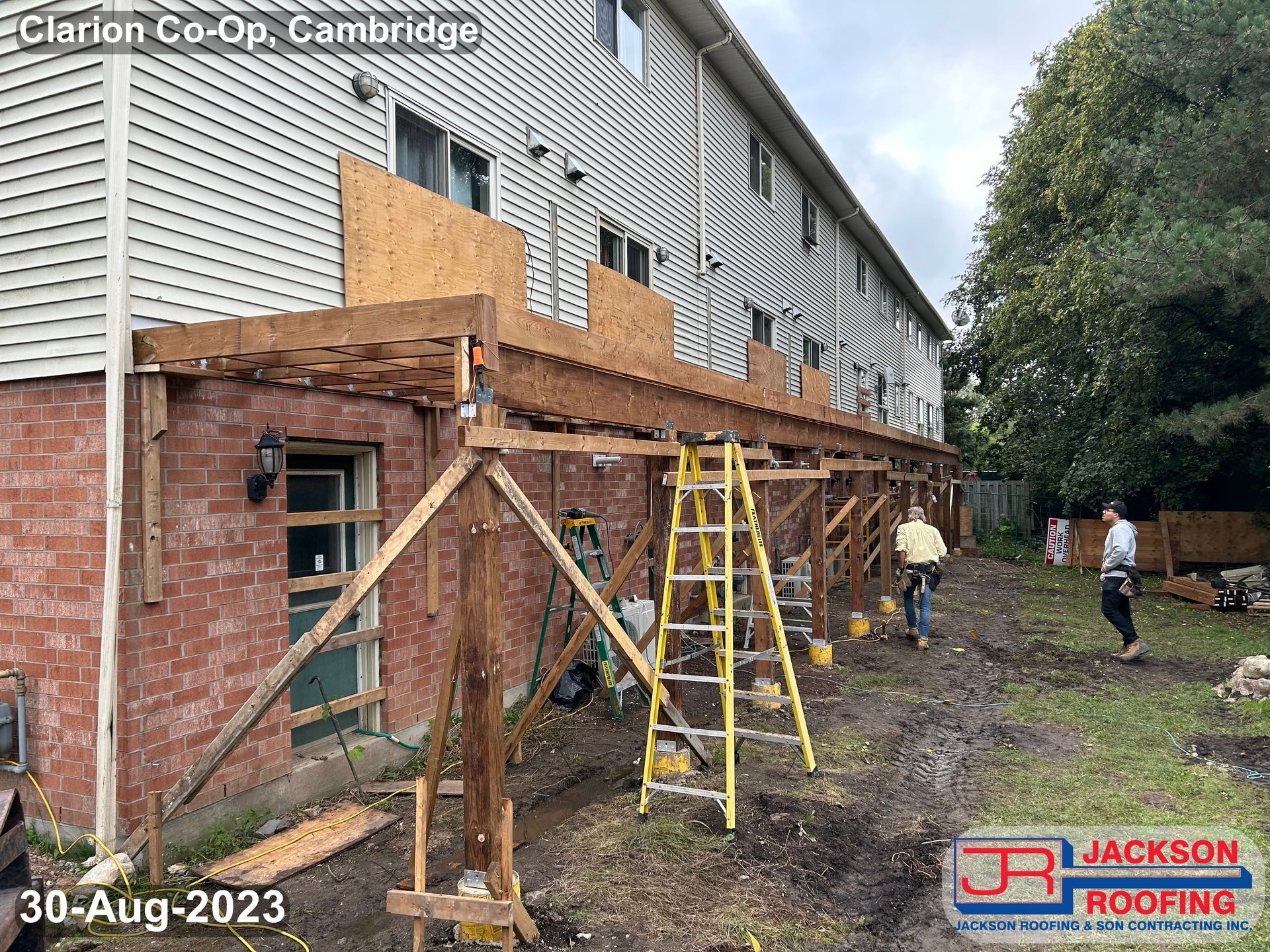 A wooden deck is being built on the side of a house.