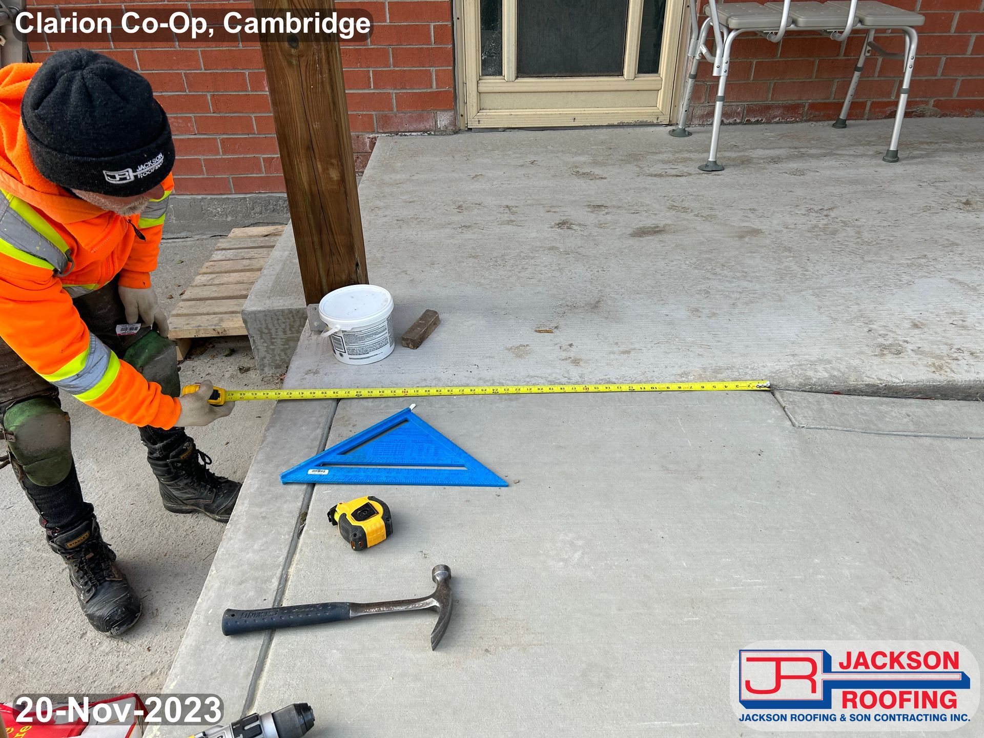 A man is measuring a concrete surface with a tape measure