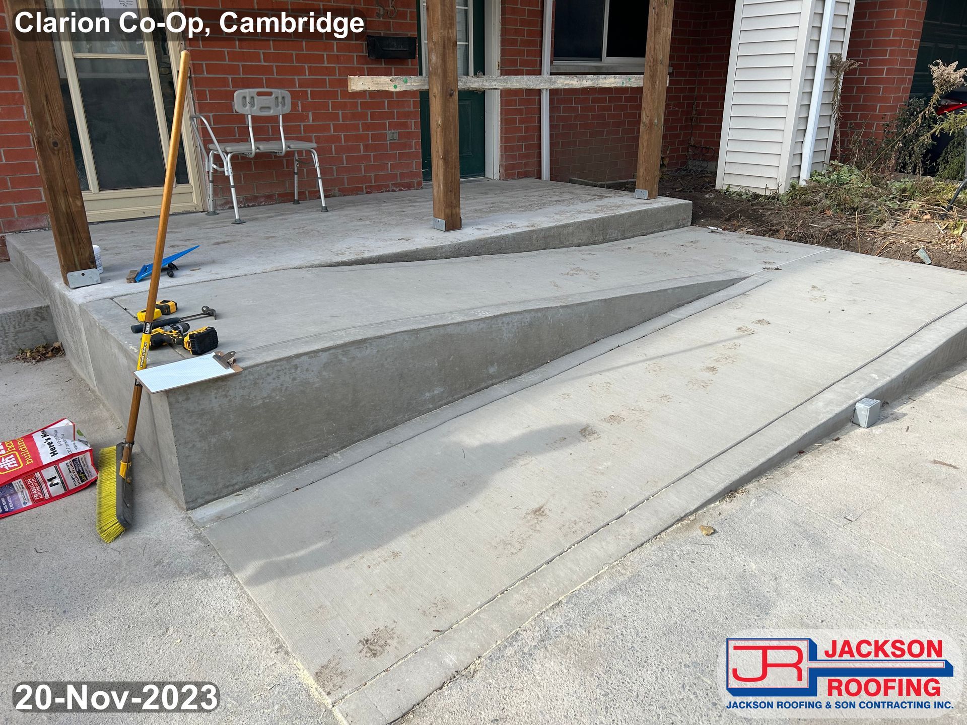 A concrete ramp is being built in front of a brick building.