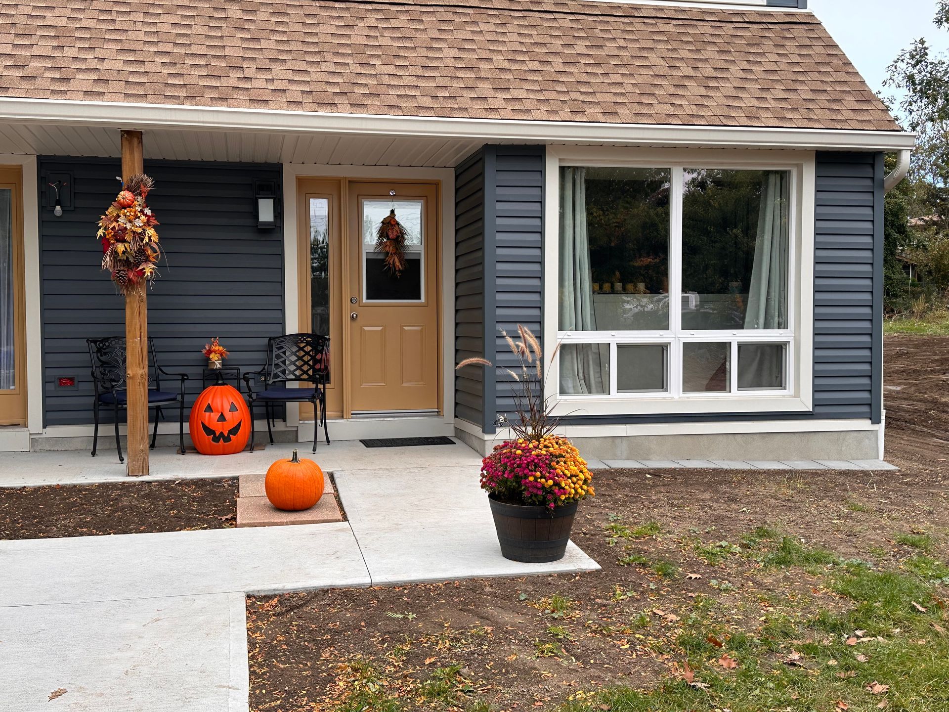 A small house with a pumpkin on the porch