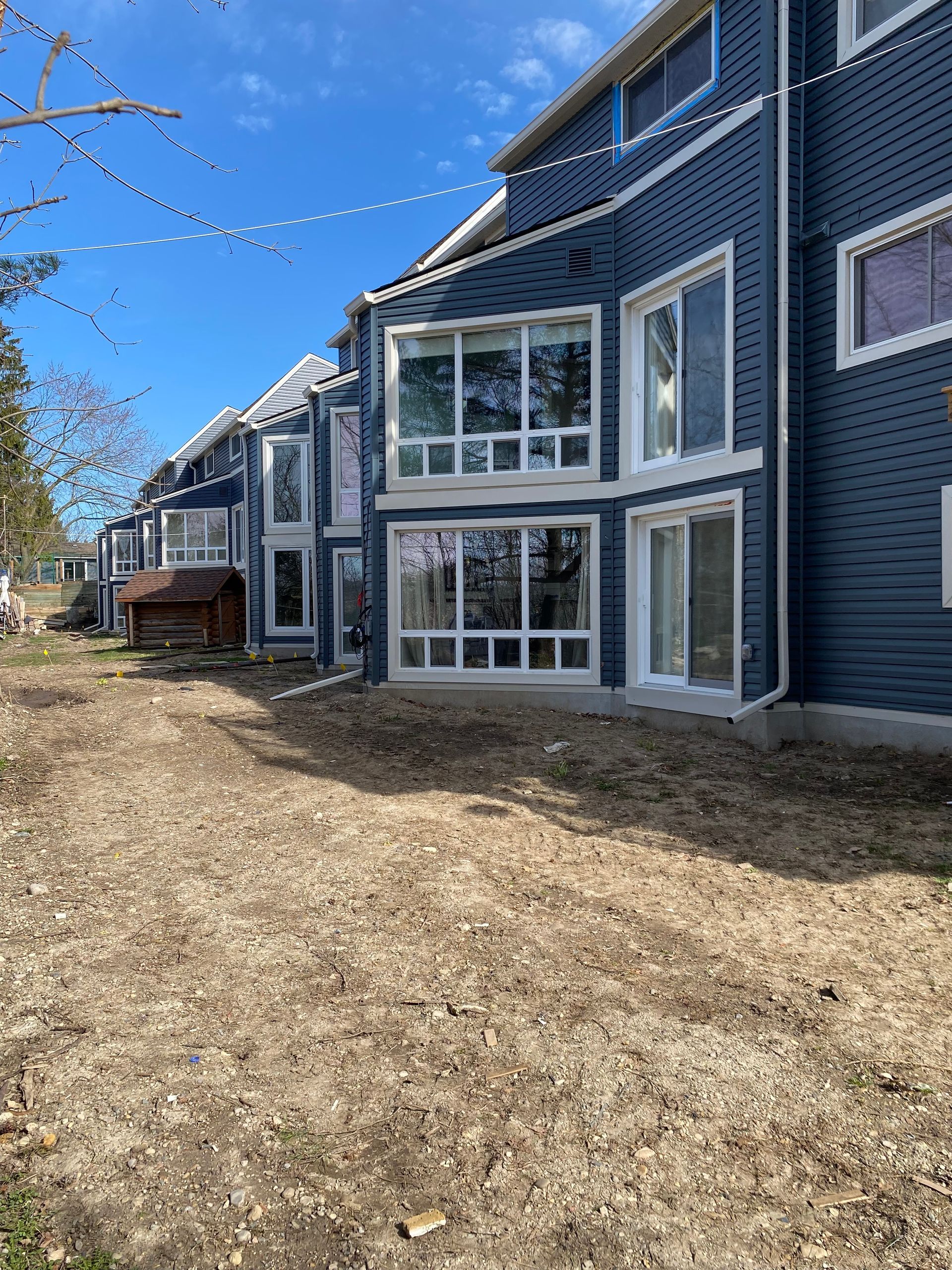 A row of houses with a lot of windows and a lot of dirt in front of them.