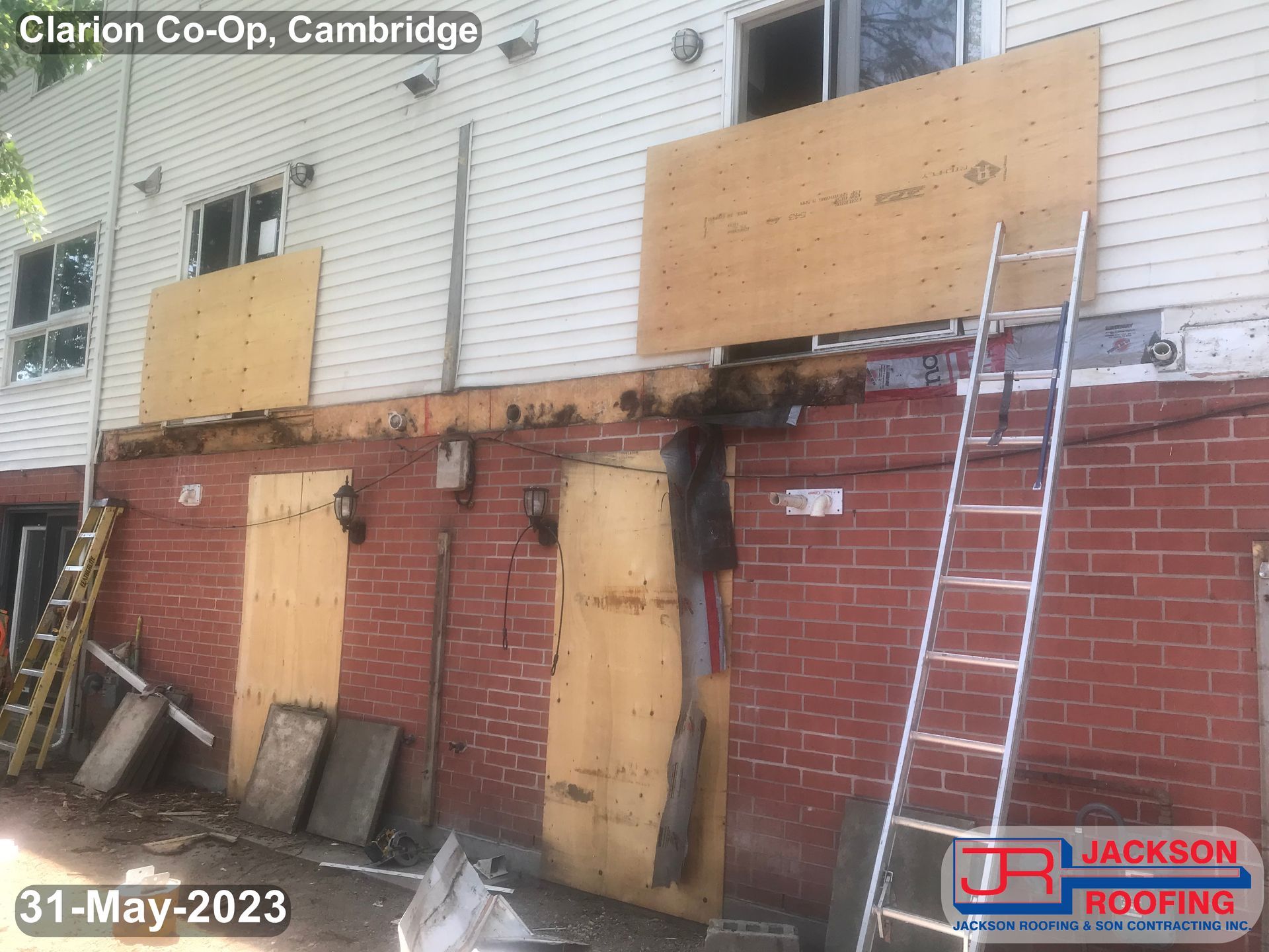 A ladder is sitting on the side of a brick building.