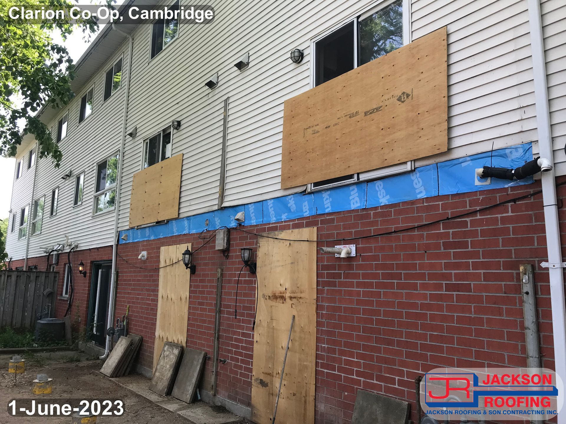 A brick building with a white siding is being remodeled by jackson roofing