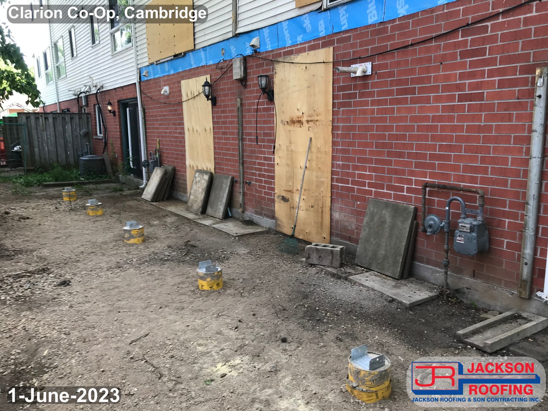 A brick building with wooden doors is being demolished.