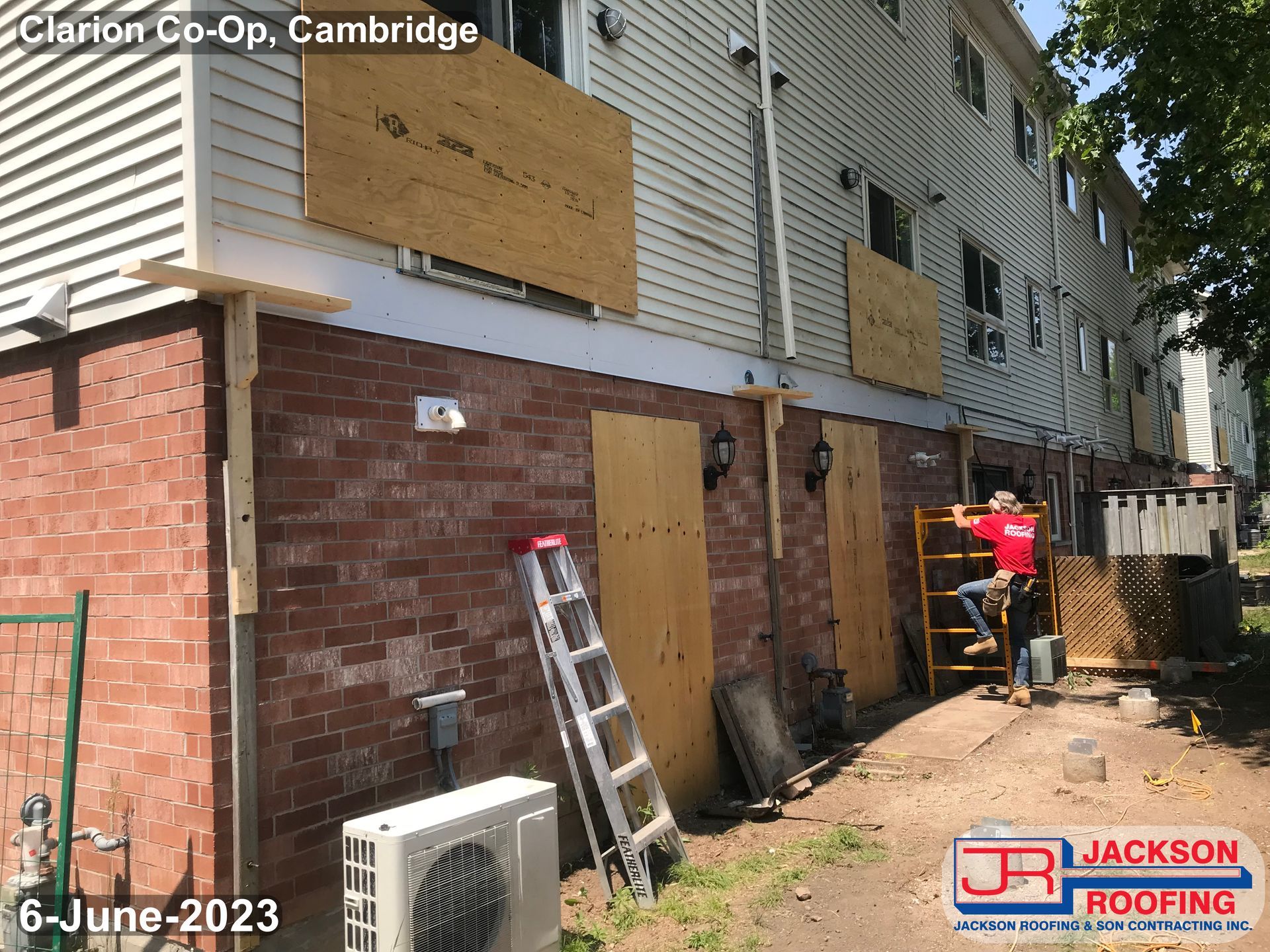 A jackson roofing company is working on a brick building