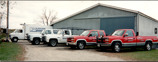 A row of trucks are parked in front of a building