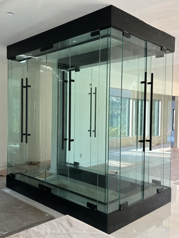 Glass entrance vestibule with black frame and double doors in a modern building lobby