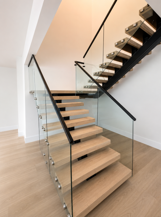 Modern home interior with floating staircase, glass railing, and white tile floor