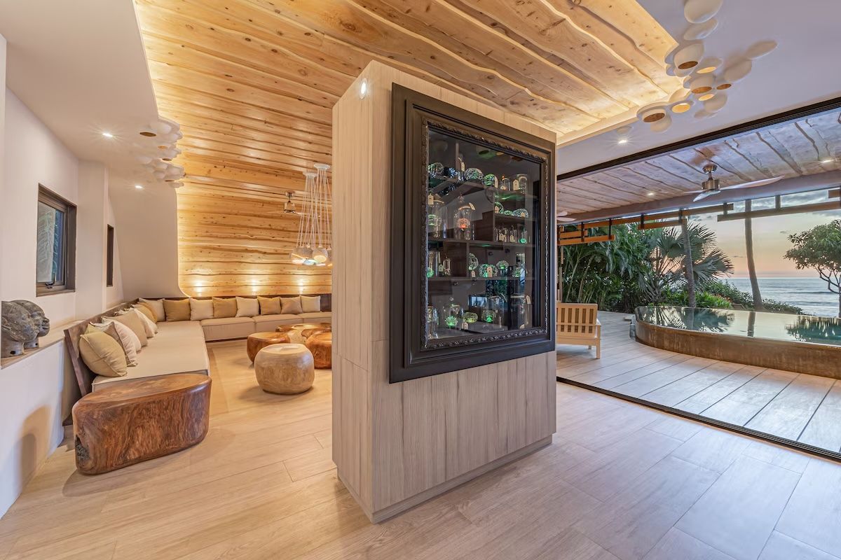 Espace lounge avec des touches de bois clair, un bar et une vue sur l'océan.