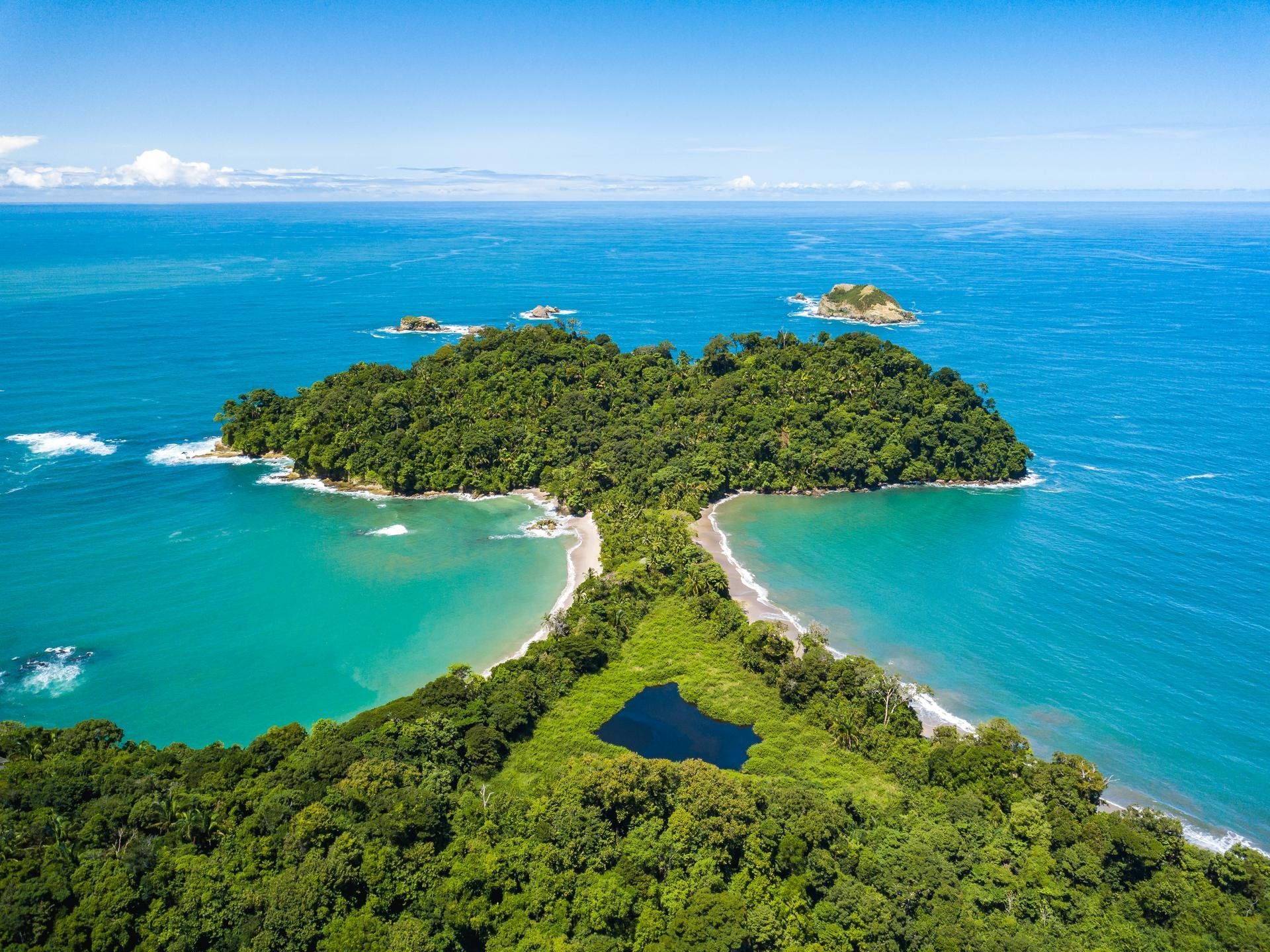 Des îles tropicales à la végétation luxuriante, reliées par une étroite plage, entourées d'eaux turquoise.