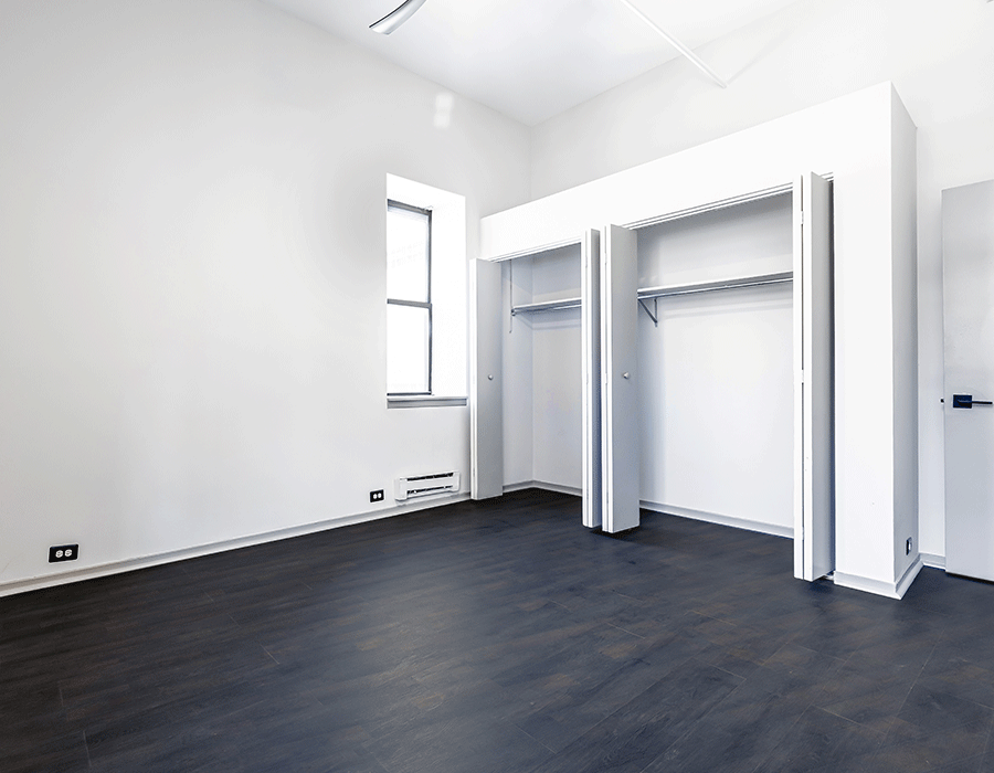 An empty room with a black floor and white walls