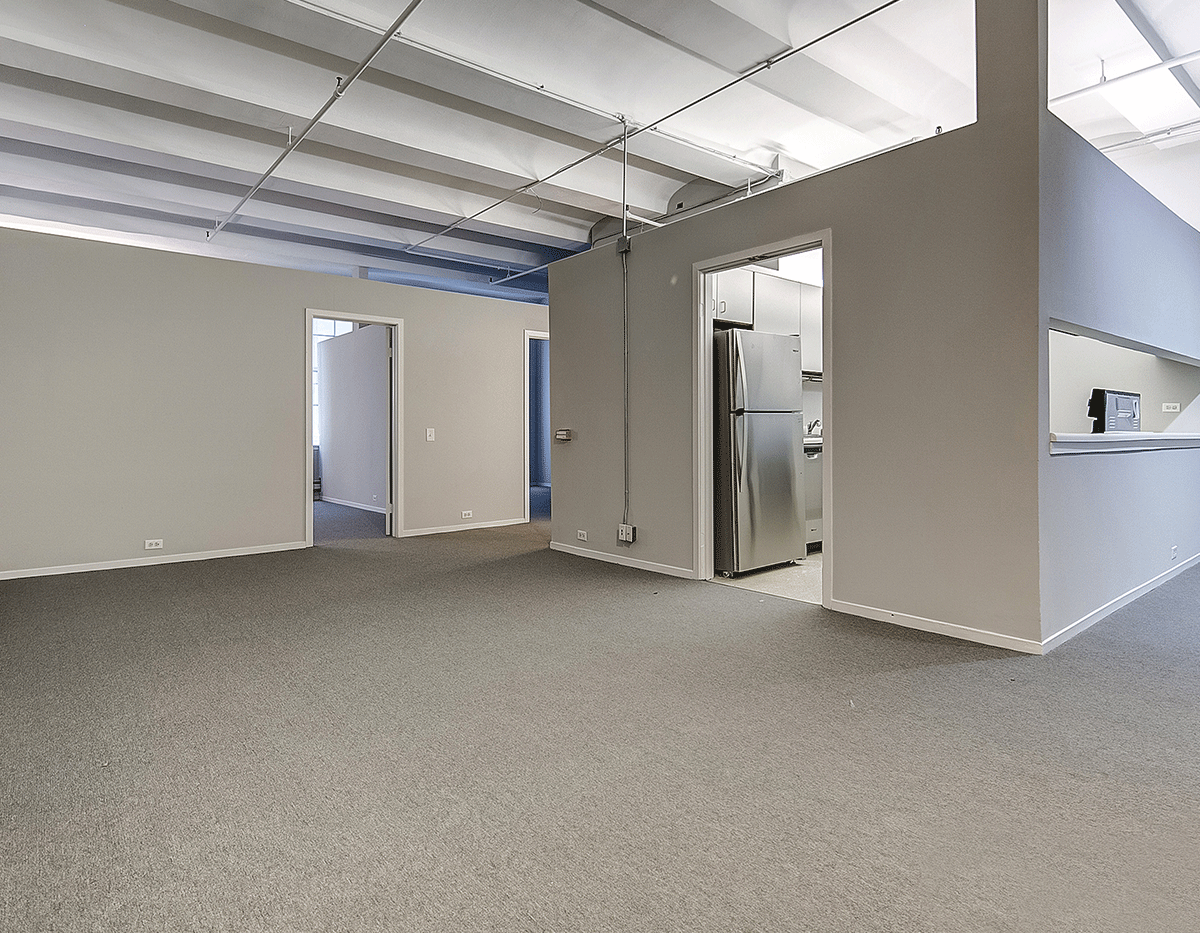 An empty room with a refrigerator in it