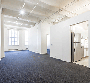 An empty room with a refrigerator and a window