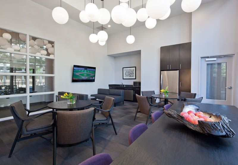 A room with tables and chairs and a bowl of fruit on the table