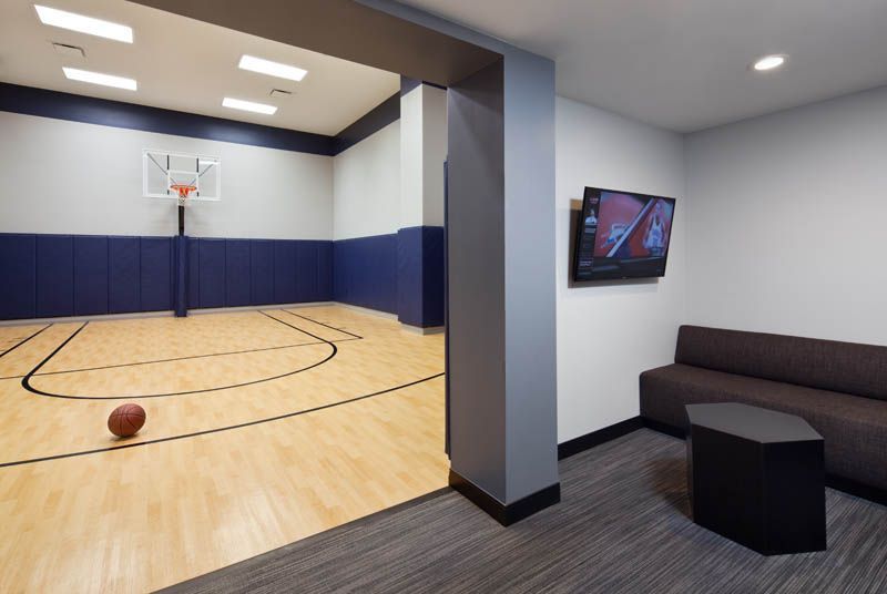 A basketball is on the floor of a basketball court in a living room.