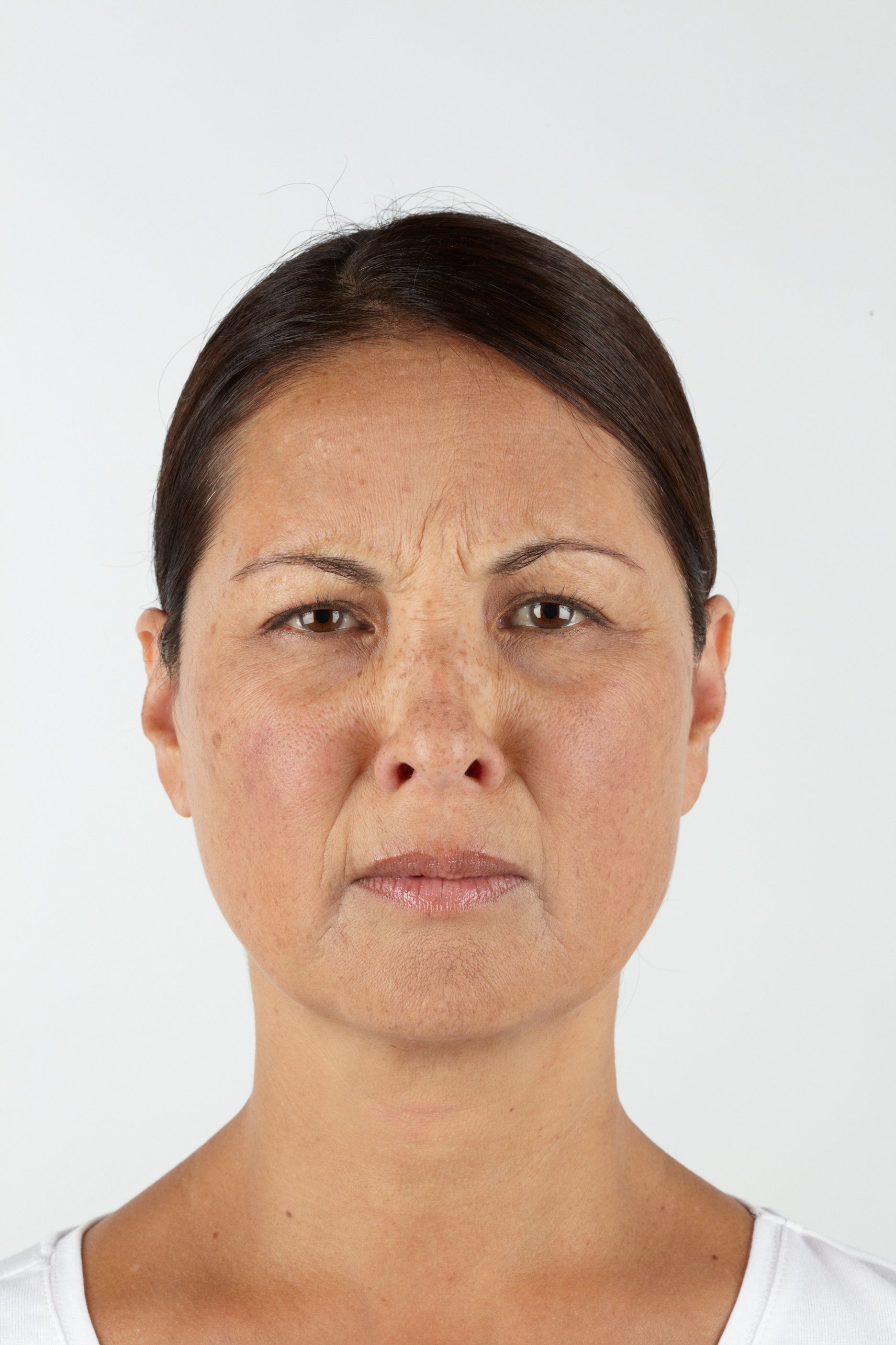 Woman with a disgusted expression, wrinkled forehead, and slight frown, against a white background.