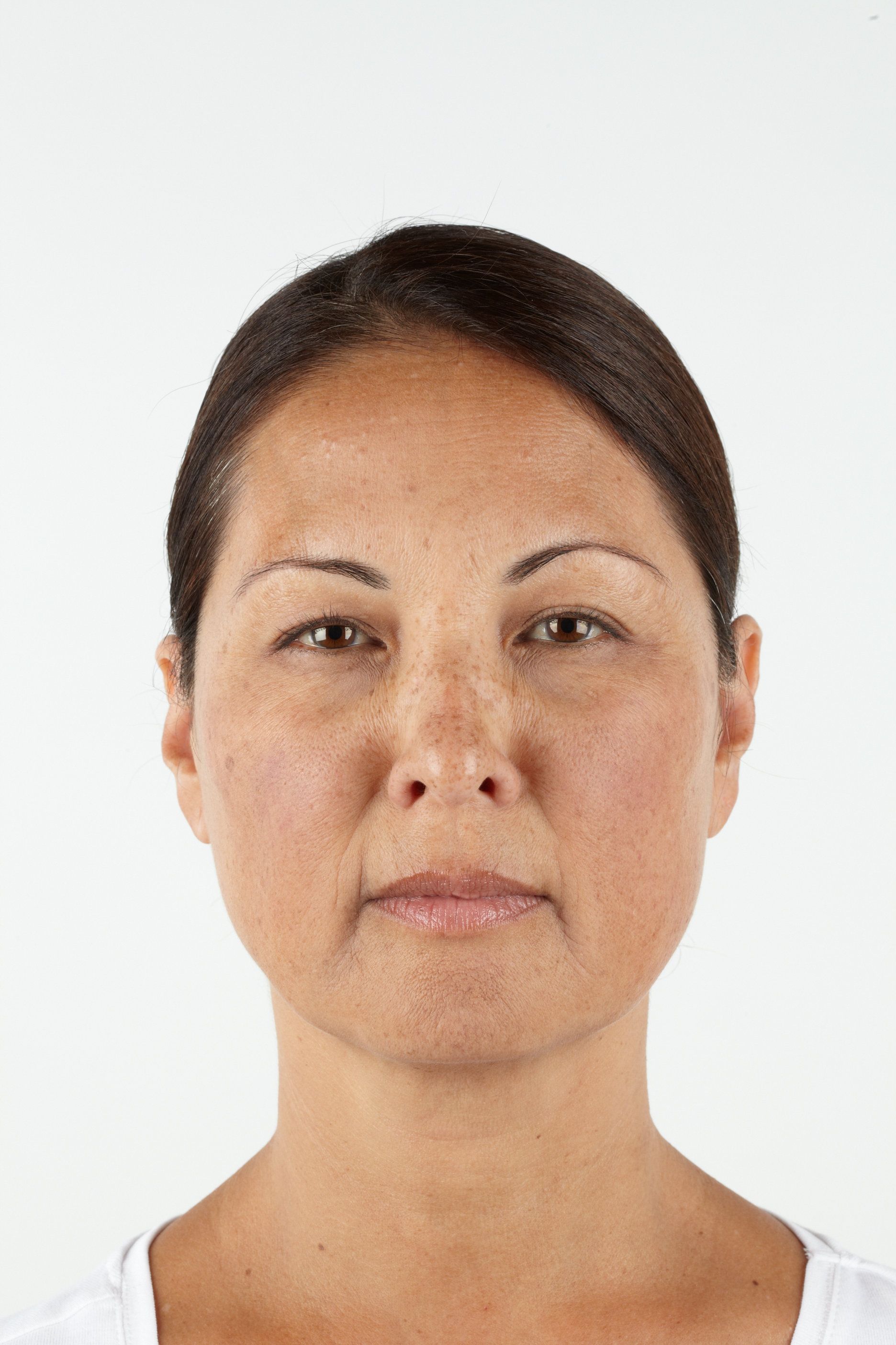 Woman with brown hair, neutral expression, freckled skin, white background.