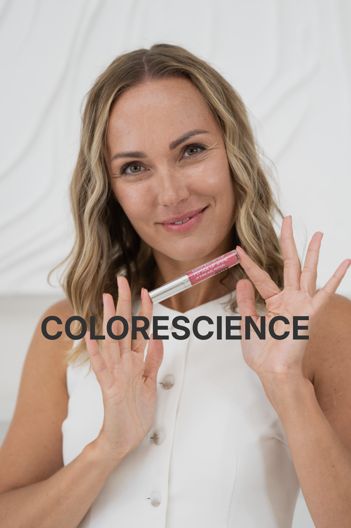 Colorescience Cosmetics in teal and white containers, including brushes, lotions, and sticks, on a peach and white surface.