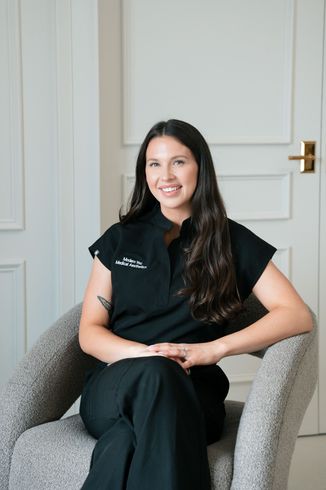 Woman with long dark hair smiling, wearing a black top.
