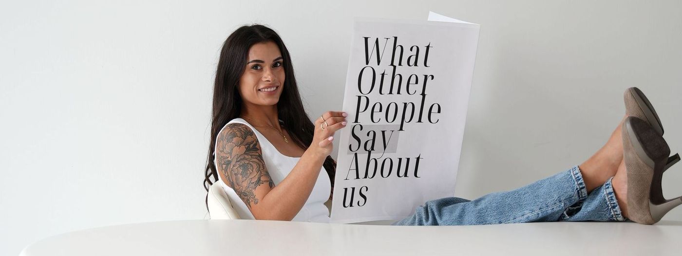 Woman smiles, holding sign that says 